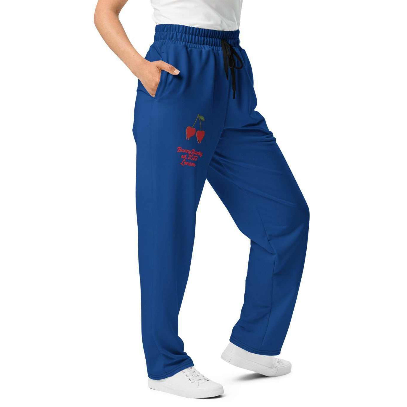 A model wearing The LA Navy Flow Joggers, showing the wide-leg cut, the playful Pop Cherry print, and the binary code on the dark navy fabric.