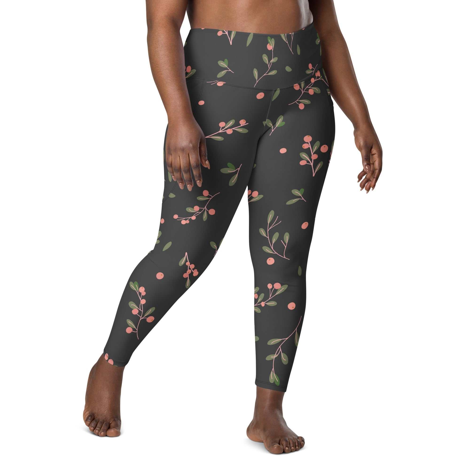 Plus size woman wearing Manchester Sculpt Leggings with pink floral print on khaki green background, high-waist fit and side pockets