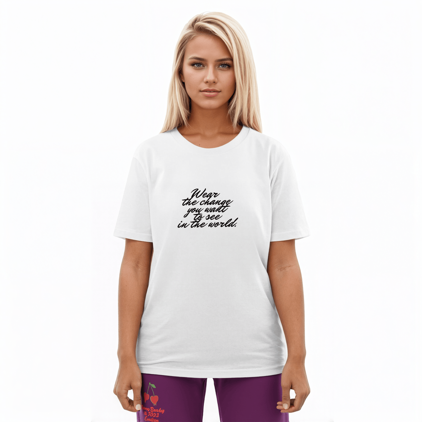 A model wearing The Manifesto Tee in 100% organic cotton, showing the "Wear the change you want to see in the world" text on the front.