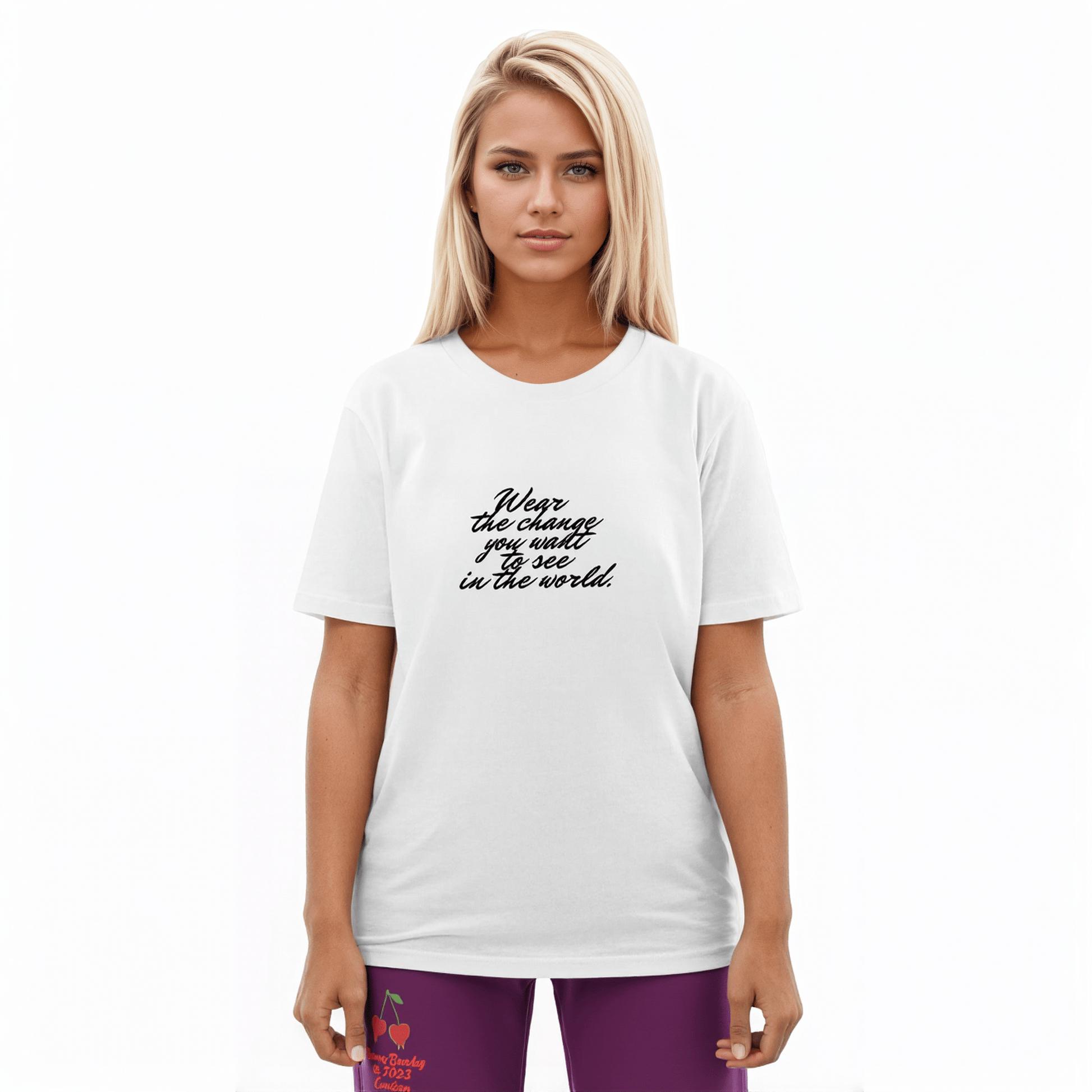 A model wearing The Manifesto Tee in 100% organic cotton, showing the "Wear the change you want to see in the world" text on the front.