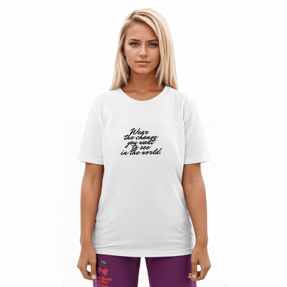 A model wearing The Manifesto Tee in 100% organic cotton, showing the "Wear the change you want to see in the world" text on the front.