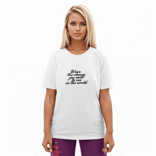 A model wearing The Manifesto Tee in 100% organic cotton, showing the "Wear the change you want to see in the world" text on the front.