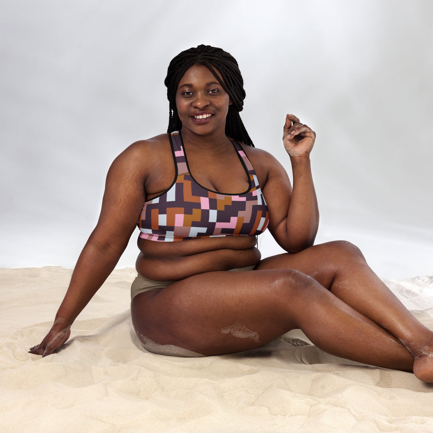 A model wearing  The Marais Performance Bra, showing the supportive fit and the sophisticated Cubism-inspired geometric print in pink, brown, and white.