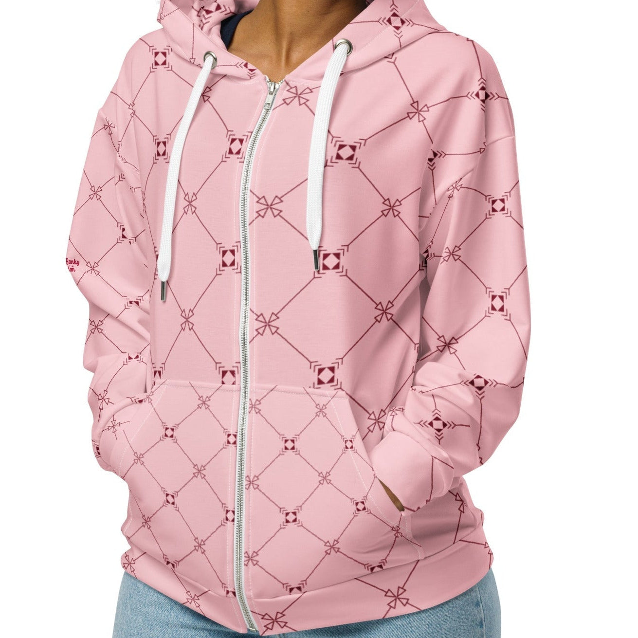 A model wearing the Mayfair Zip Hoodie, showing the unisex fit and the sophisticated burgundy and pink geometric monogram print.
