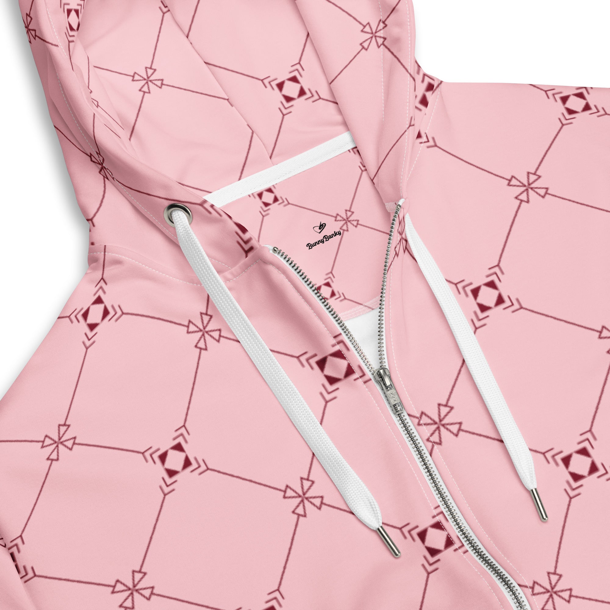 Close-up of the Mayfair Hoodie's fabric, highlighting the precise burgundy geometric monogram inspired effect on the pink background and the soft texture of the 95% certified recycled polyester.