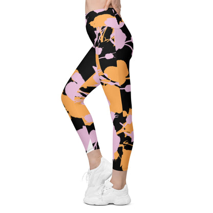 A model wearing The Miami Sculpt Leggings, showing the sculpting fit and the dynamic pink and orange splashes print on the black fabric.
