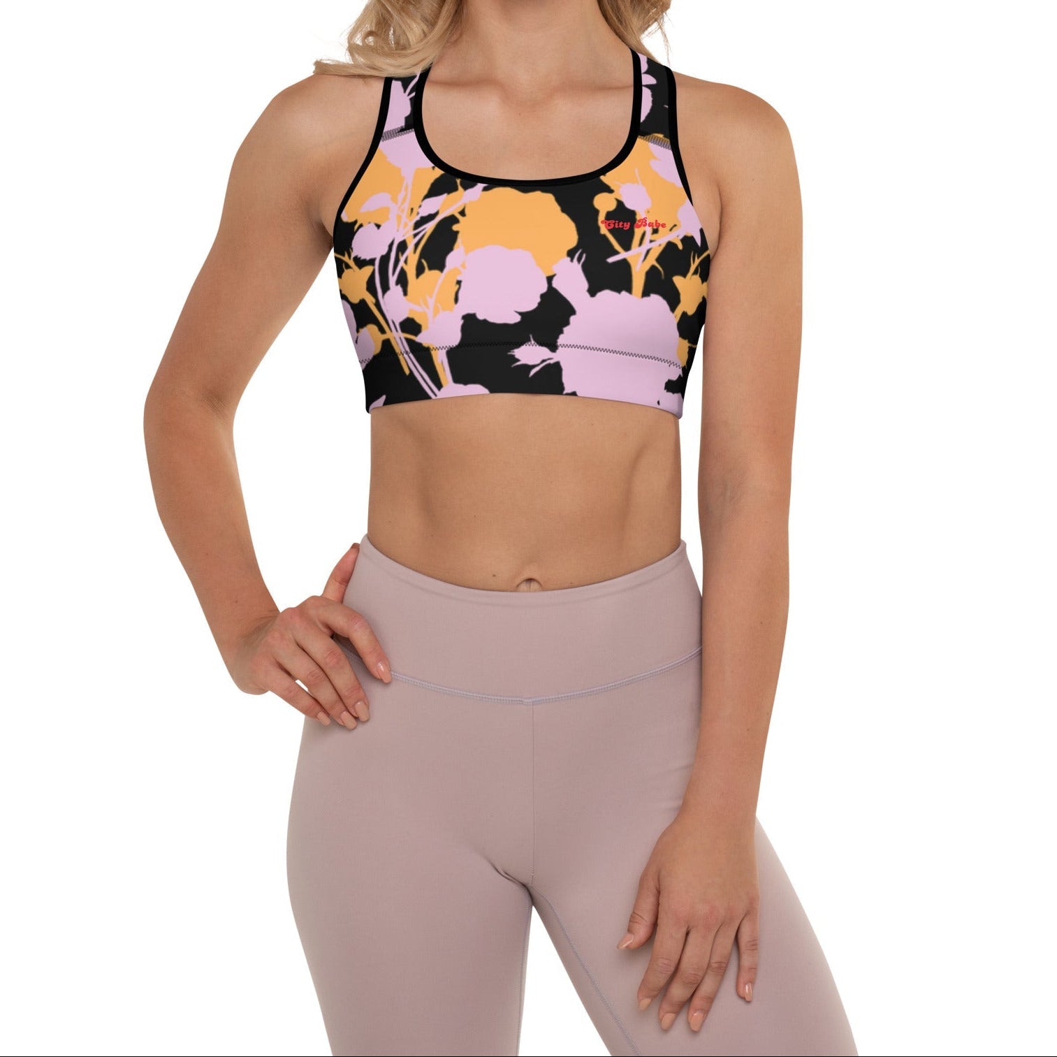 A model wearing The Miami Performance Bra, showing the supportive fit and the vibrant pink and orange splashes print.
