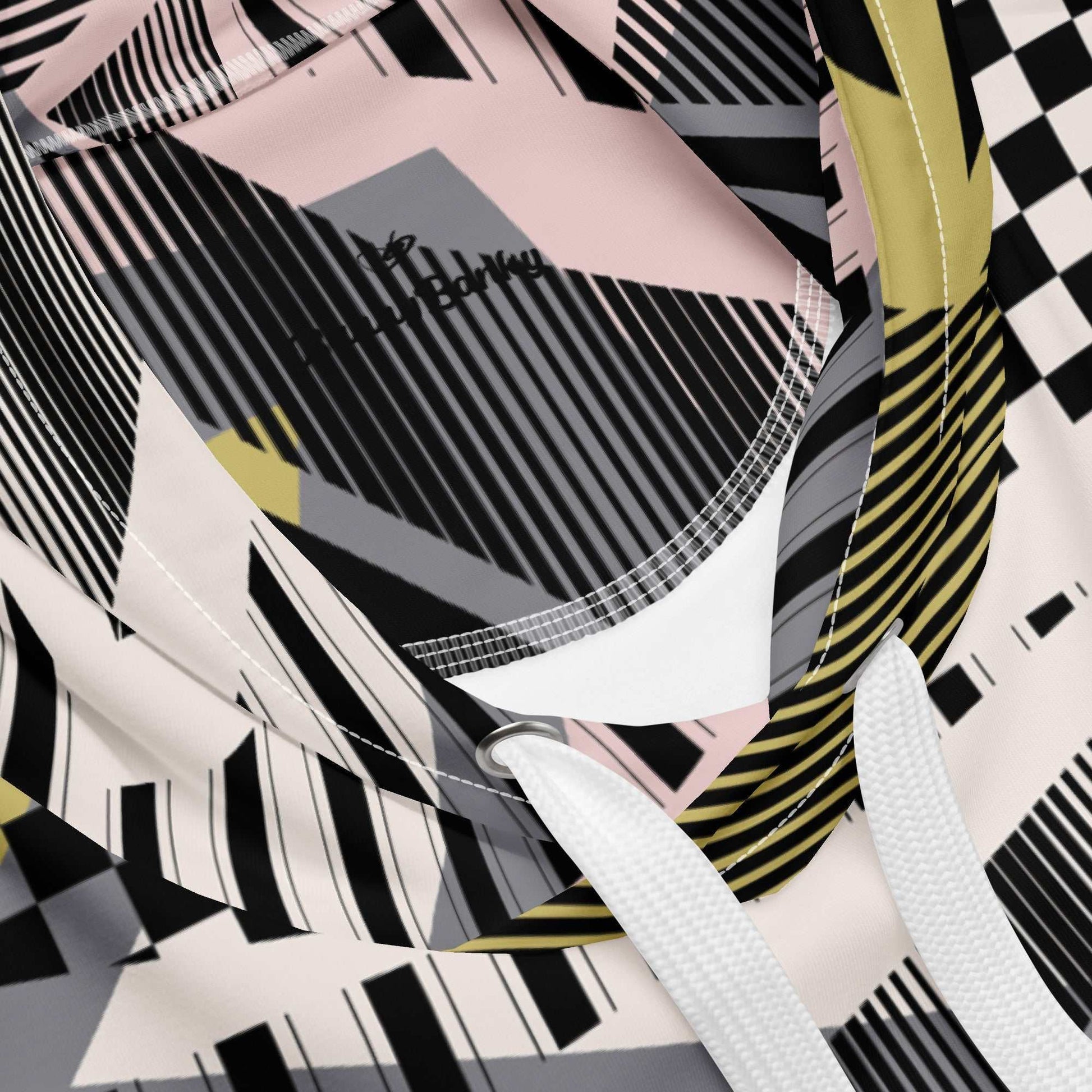 A close up of the Miami Resort Hoodie. The image highlights the Art Deco-inspired pattern of checkers and pinstripes in soft pink, sand, and olive tones, featuring red London branding.