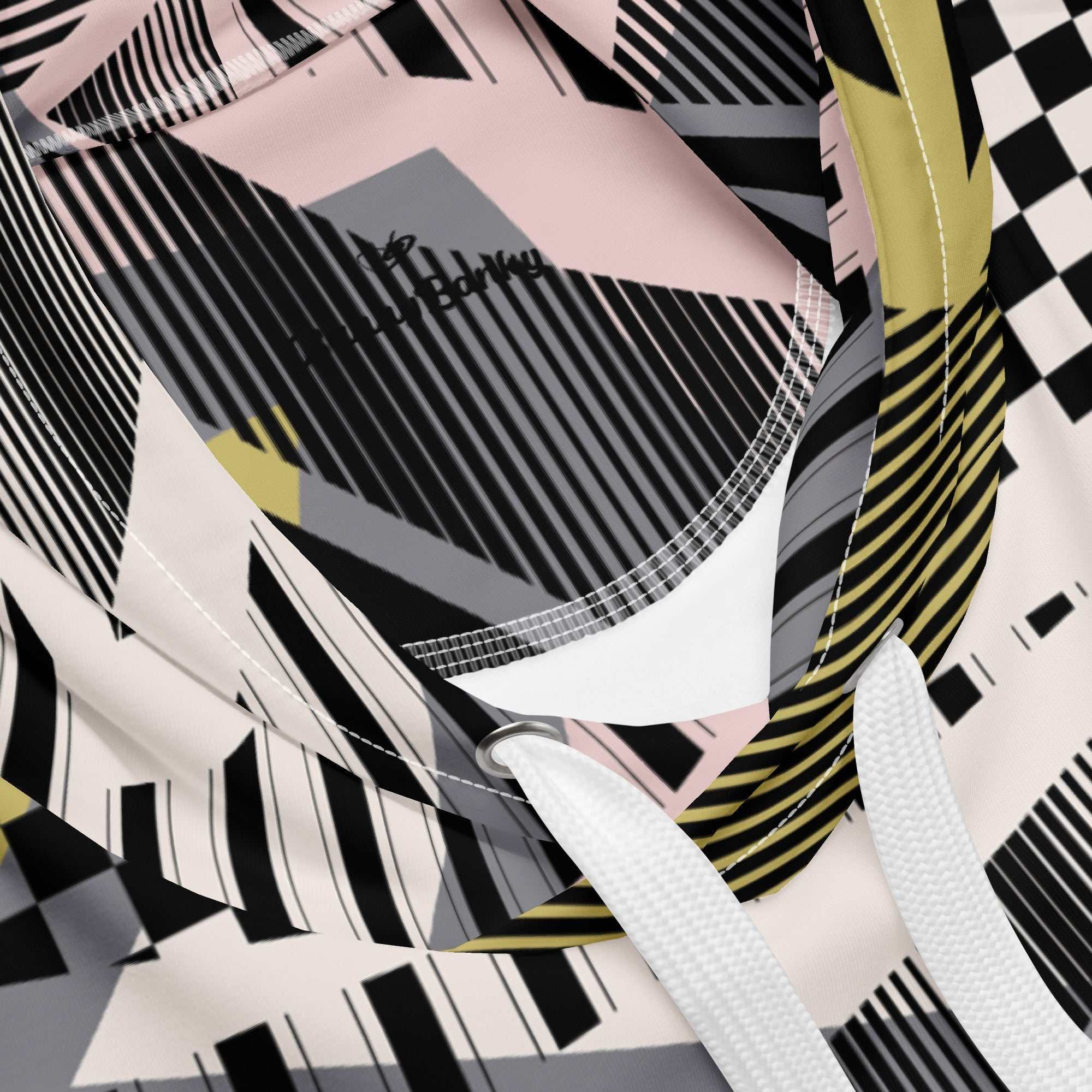 A close up of the Miami Resort Hoodie. The image highlights the Art Deco-inspired pattern of checkers and pinstripes in soft pink, sand, and olive tones, featuring red London branding.