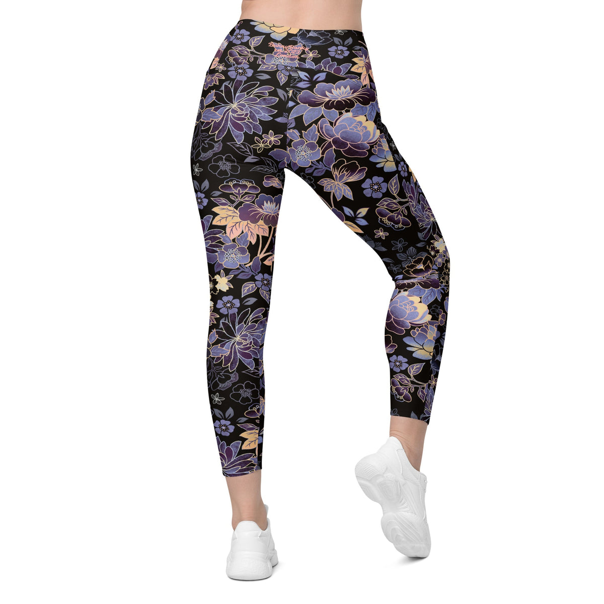 Model wearing the Milano sculpt leggings in purple and beige floral pattern on a black fabric.