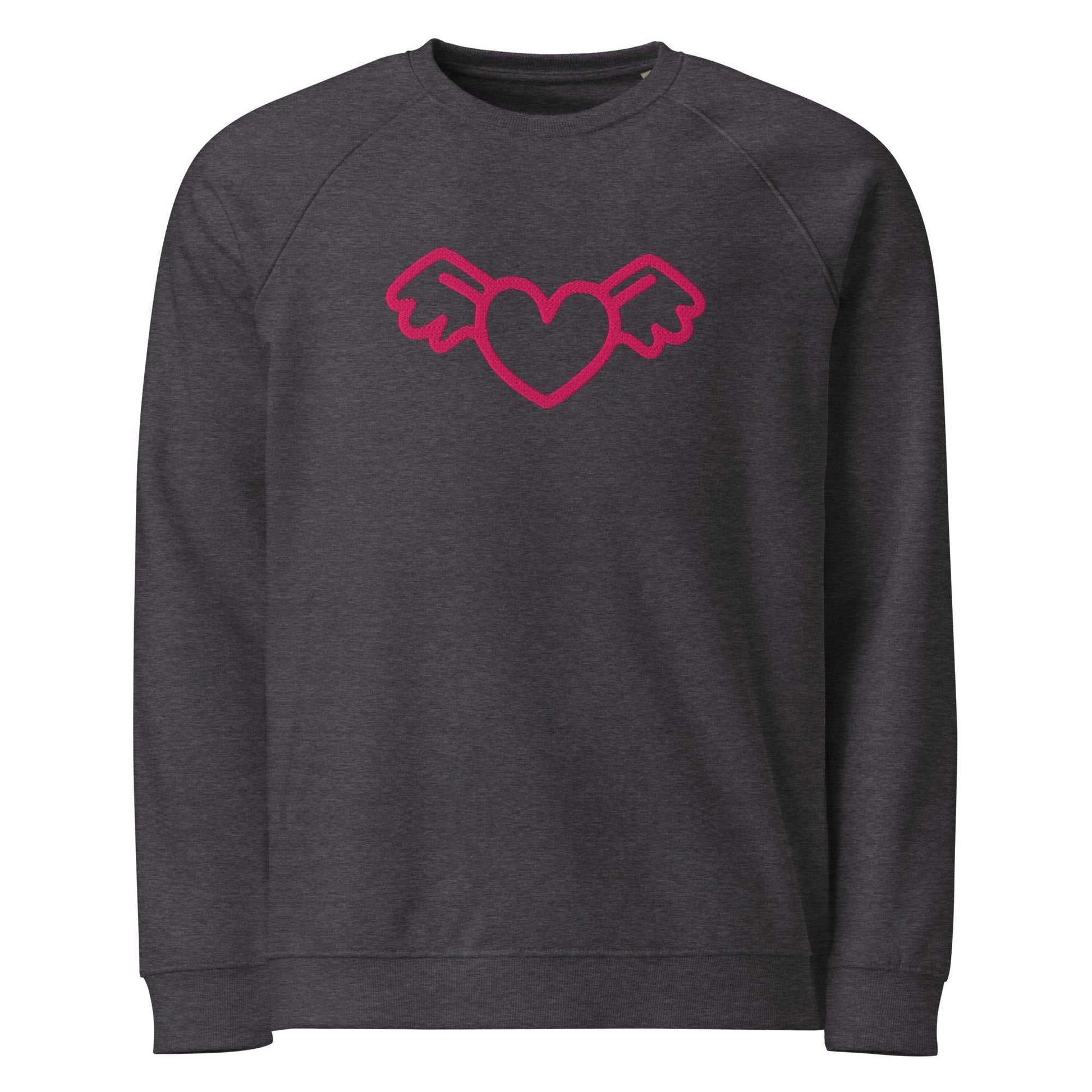 A close-up of The Monument Organic Sweatshirt, showing the detailed embroidery of a vibrant pink heart with wings on the 100% organic cotton fabric.