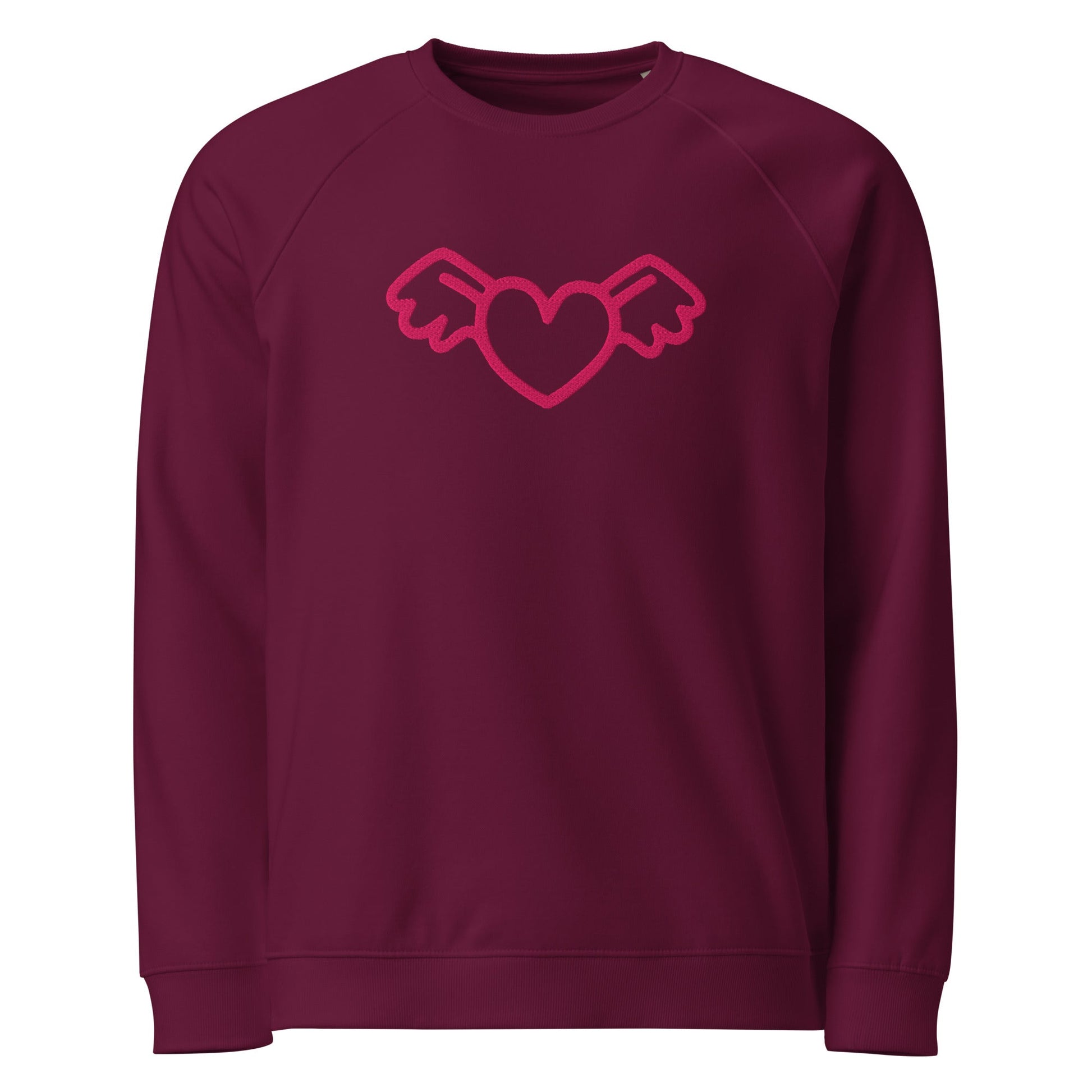 A close-up of The Monument Organic Sweatshirt, showing the detailed embroidery of a vibrant pink heart with wings on the 100% organic cotton fabric.