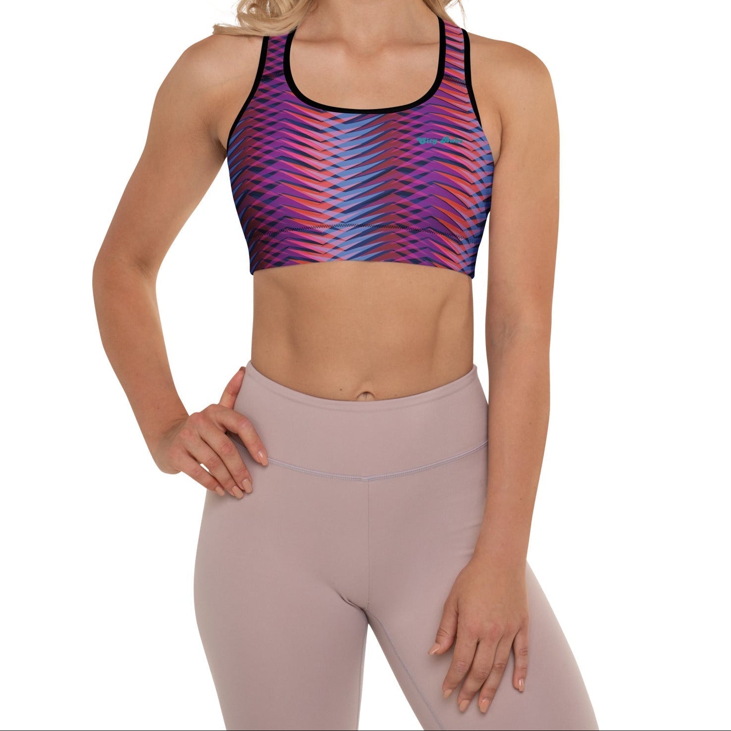 A model wearing The Moorgate Performance Bra, showing the supportive fit and the dynamic graphic arrow print in vibrant pink, orange, and blue hues.