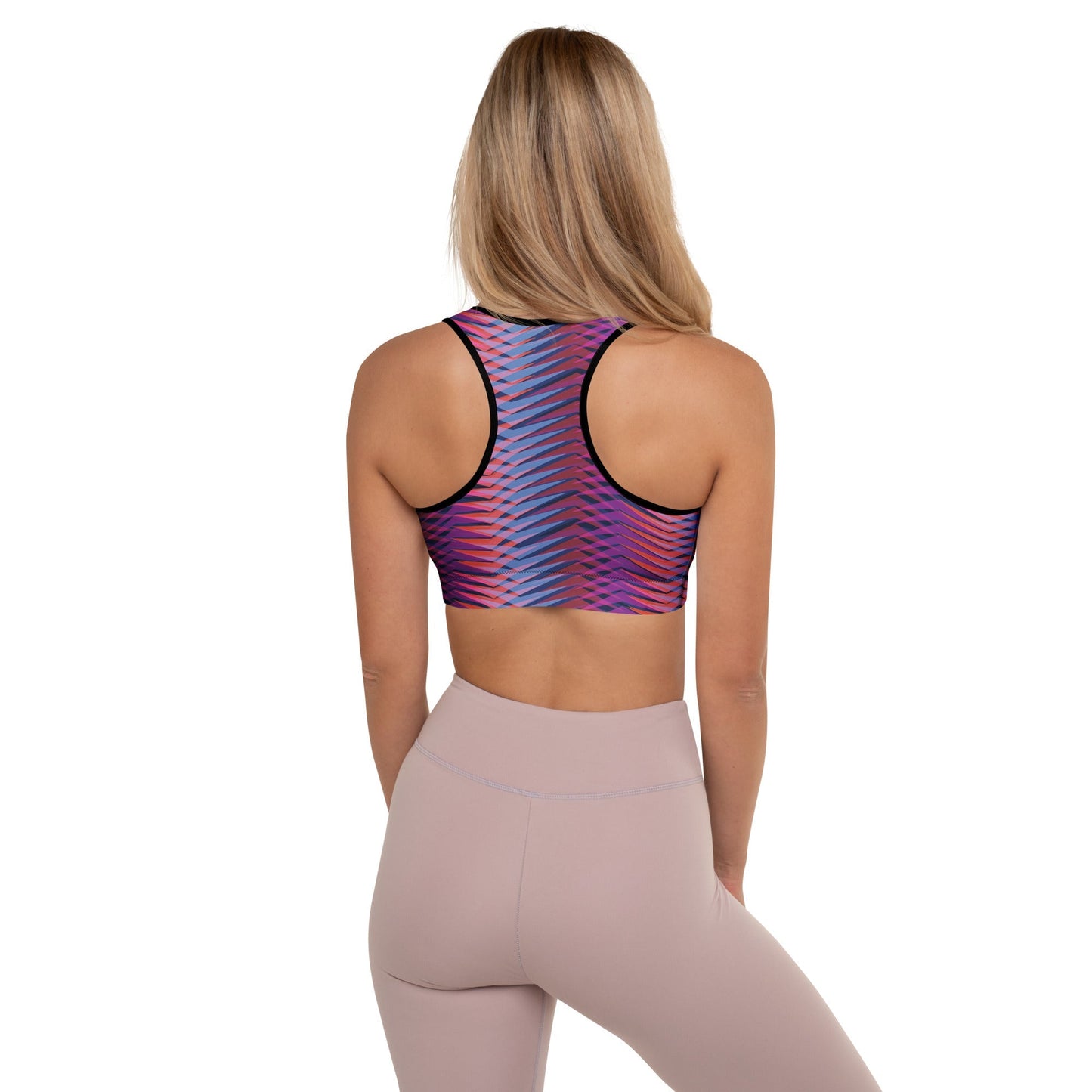 A model wearing The Moorgate Performance Bra, showing the supportive fit and the dynamic graphic arrow print in vibrant pink, orange, and blue hues.