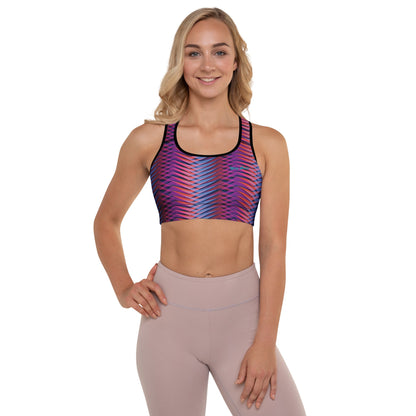 A model wearing The Moorgate Performance Bra, showing the supportive fit and the dynamic graphic arrow print in vibrant pink, orange, and blue hues.