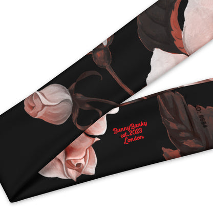 The Paris headband is an elastic featuring a floral print with pale pink and white flowers on a solid black background.