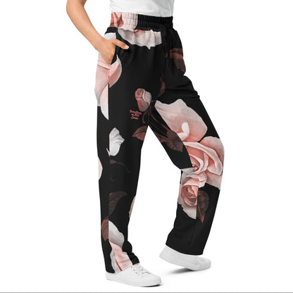A model wearing The Paris Flow  Joggers, showing the wide-leg cut and the dramatic XL pale pink rose print.