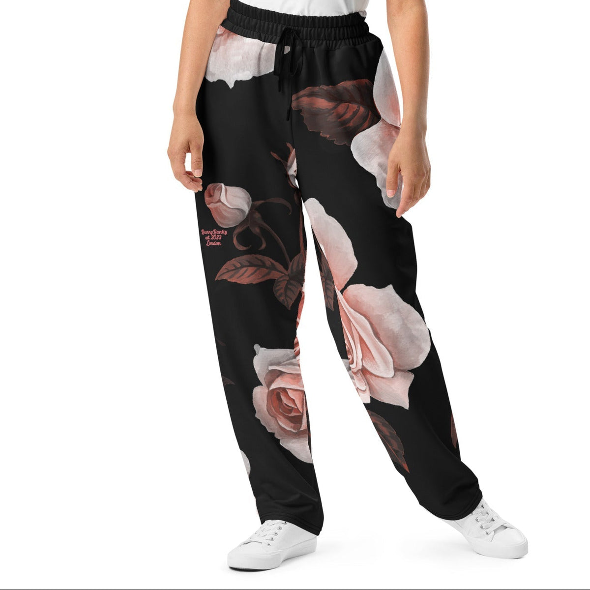 A model wearing The Paris Flow  Joggers, showing the wide-leg cut and the dramatic XL pale pink rose print.
