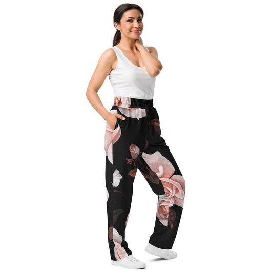 A model wearing The Paris Flow Wide Joggers, showing the wide-leg cut and the dramatic XL pale pink rose print.