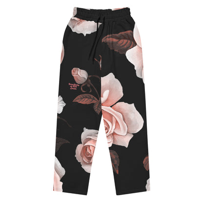 A close-up of The Paris Flow Wide Joggers, highlighting the detailed XL pale pink rose print against the black background and showcasing the soft, recycled polyester fabric texture.