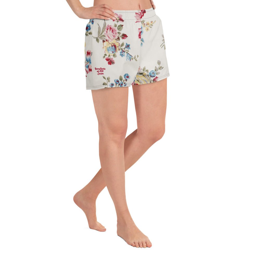model wearing the Pink Blush Athletic Shorts, highlighting the delicate pink and sky blue floral print and the athletic 2.5″ inseam.