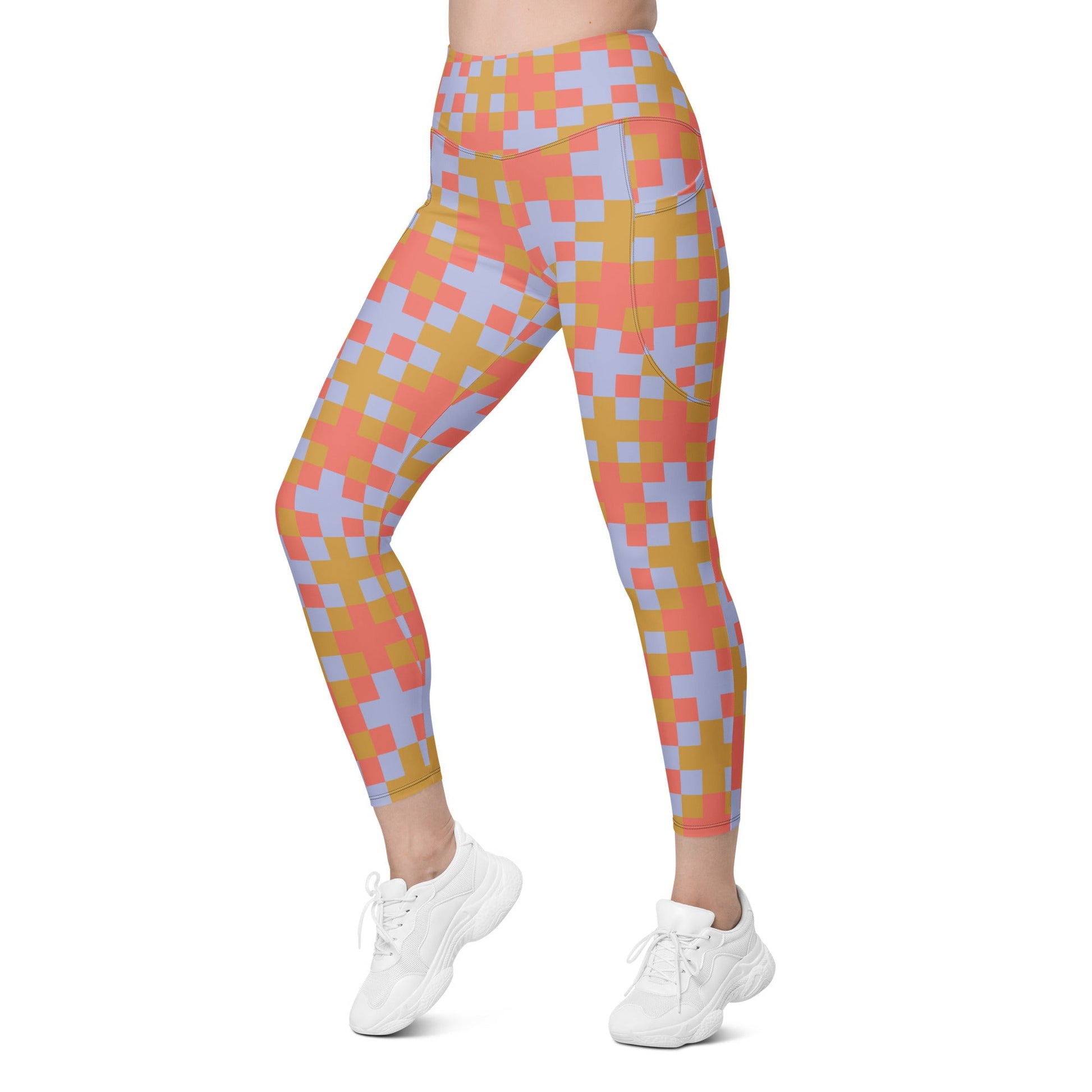 A model wearing the high-waisted Pixel Glam Sculpt Leggings, highlighting the colorful terracotta, gold, and blue pixelated grid pattern and the integrated side pocket design.