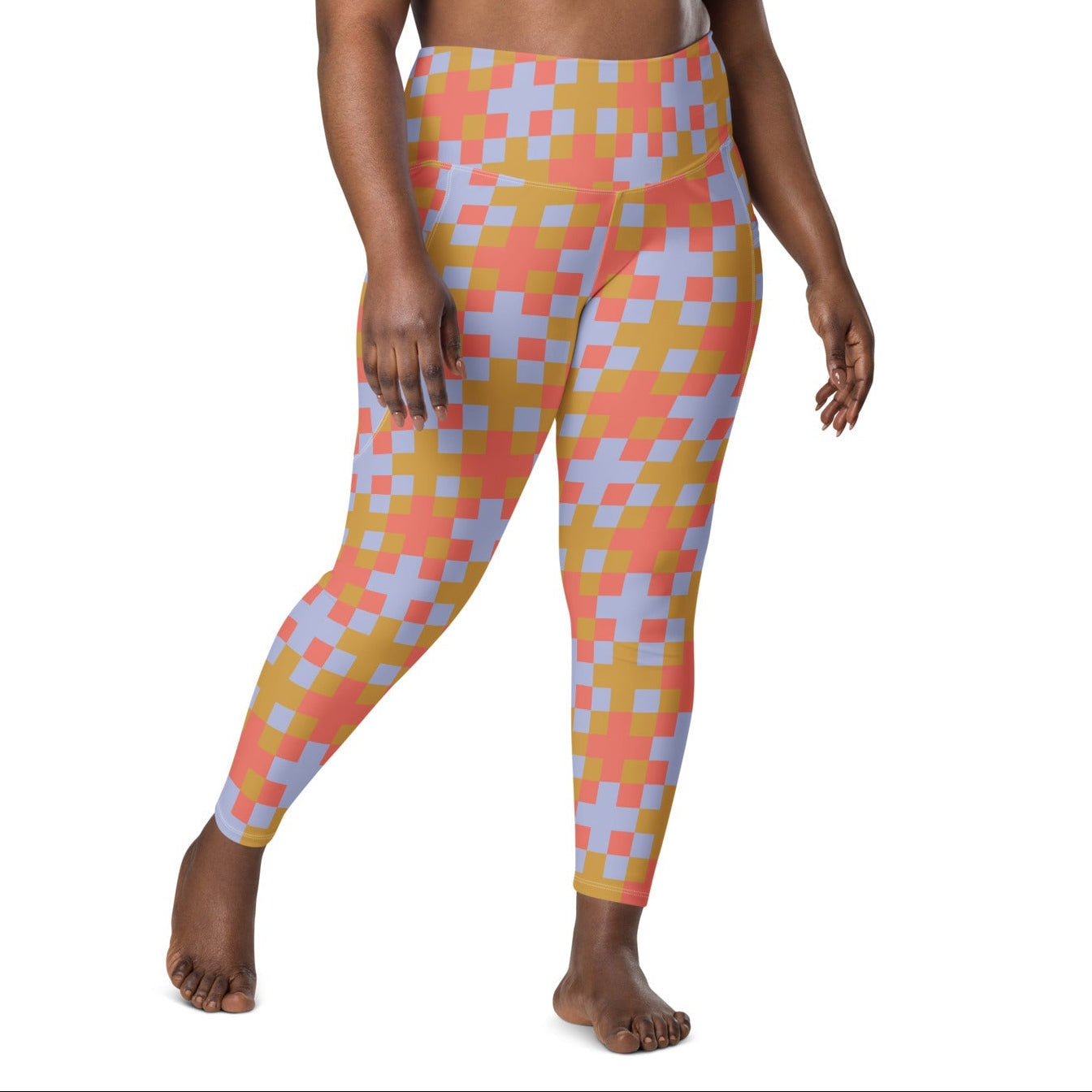 A model wearing the high-waisted Pixel Glam Sculpt Leggings, highlighting the colorful terracotta, gold, and blue pixelated grid pattern and the integrated side pocket design.
