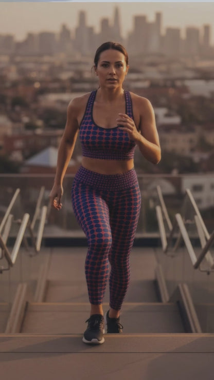 A BunnyBankY AI proprietary model wearing the complete Embankment set (Performance Bra and Sculpt Leggings) in a video. The model is actively going up stairs in a dynamic city open space, showcasing the sculpting fit and the high-contrast fuchsia and navy geometric print in motion.