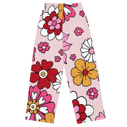 the primrose hill flow joggers. pink wide-leg pants with a retro floral print, styled with a white crop top and white sneakers against a plain white background.