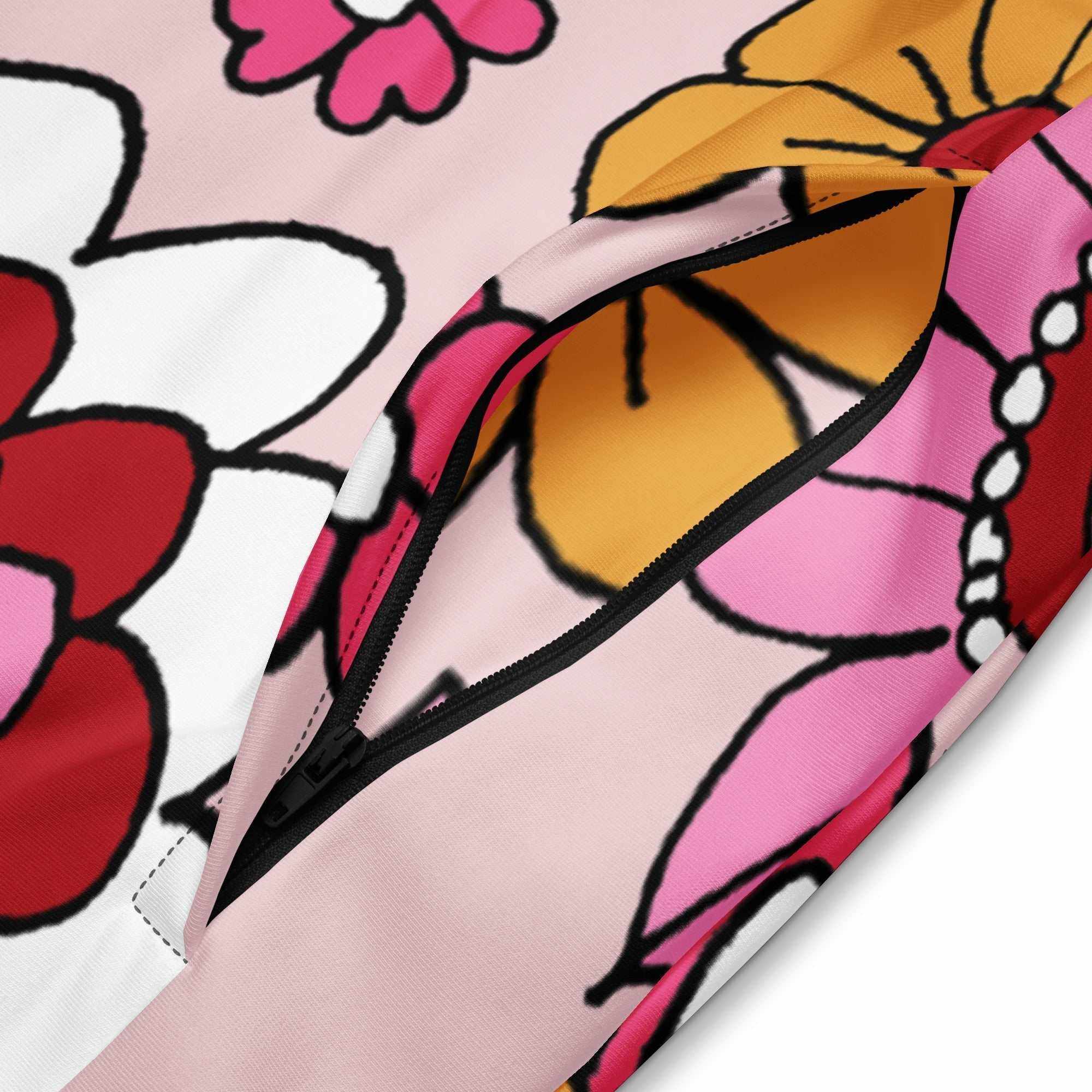 A close-up of The Primrose Hill Track Jacket's recycled polyester fabric, highlighting the texture and the intricate, oversized pink and yellow floral print detail.