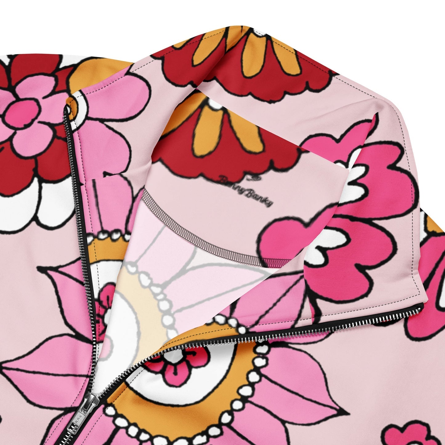 A close-up of The Primrose Hill Track Jacket's recycled polyester fabric, highlighting the texture and the intricate, oversized pink and yellow floral print detail.