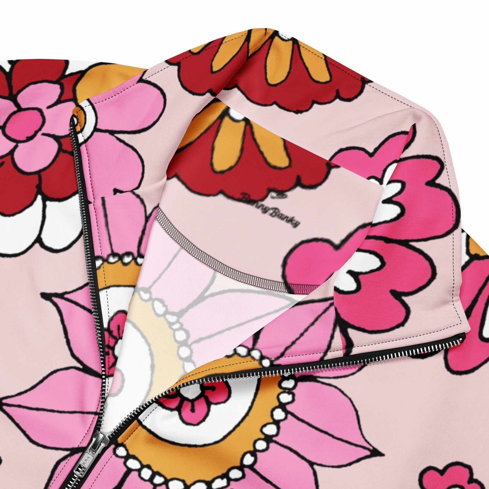 A close-up of The Primrose Hill Track Jacket's recycled polyester fabric, highlighting the texture and the intricate, oversized pink and yellow floral print detail.