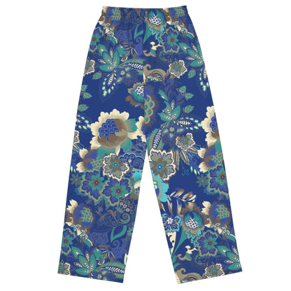 the rio flow joggers, wide-leg cut with a detailed botanical pattern in blue, green, and gold, paired with a white t-shirt and white sneakers, set against a plain white background.