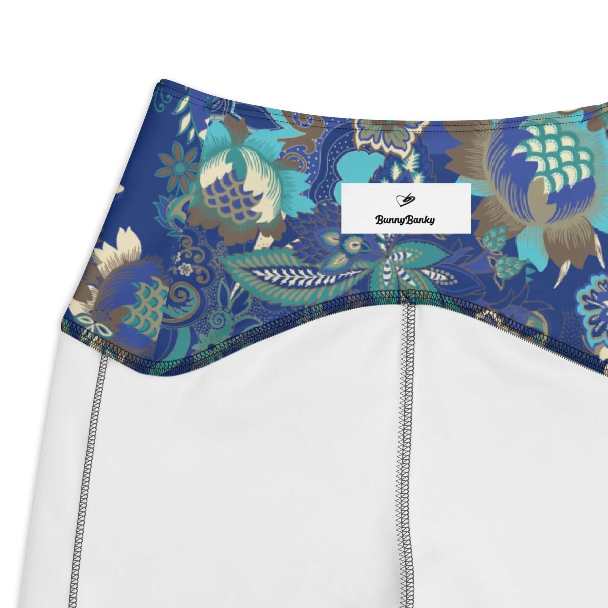Aclose up of the Rio Sculpt Leggings in the bright blue floral print, showing the BunnyBankY Iconic Logo the flattering high-waisted fit and side pocket detail.nd 