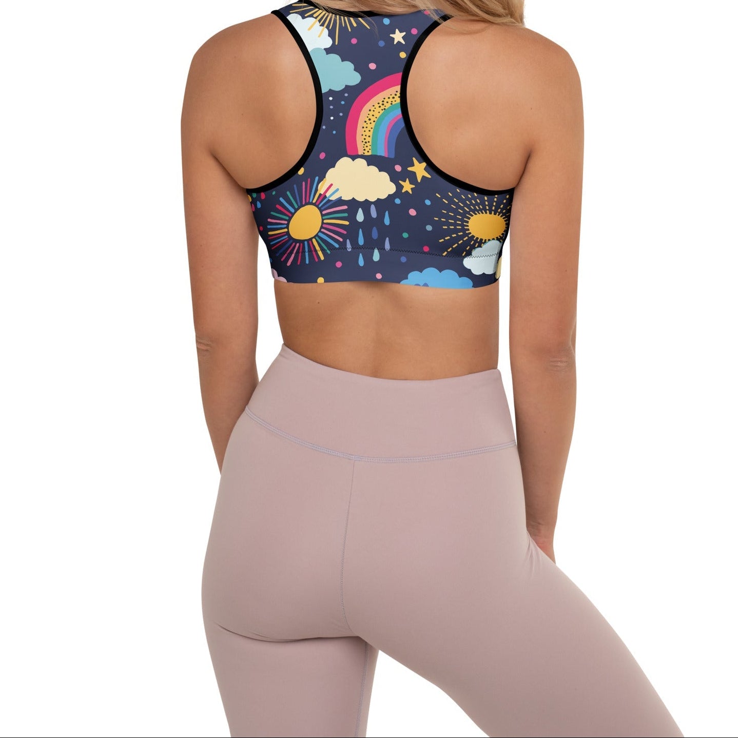 A model wearing the Riverside Performance Bra showcasing the dreamlike print of clouds, stars and rainbows on navy blue background and the racer back.