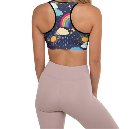 A model wearing the Riverside Performance Bra showcasing the dreamlike print of clouds, stars and rainbows on navy blue background and the racer back.