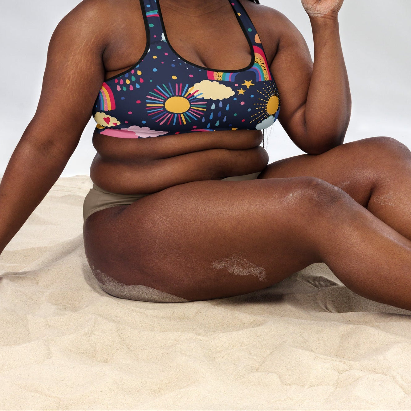 A model wearing the Riverside Performance Bra showcasing the dreamlike print of clouds, stars and rainbows on navy blue background 