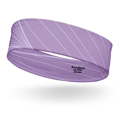 The Roma Headband. A lavender purple athletic headband with a white diagonal stripe pattern and black embroidered text reading 'BunnyBanky est. 2023 London' on a white background.