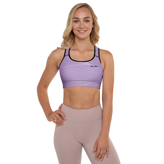 A model wearing the Roma Digital Atelier Performance Bra, showing the supportive fit, racer back design, and the graphic spiral lines in motion on the soft light lilac background.