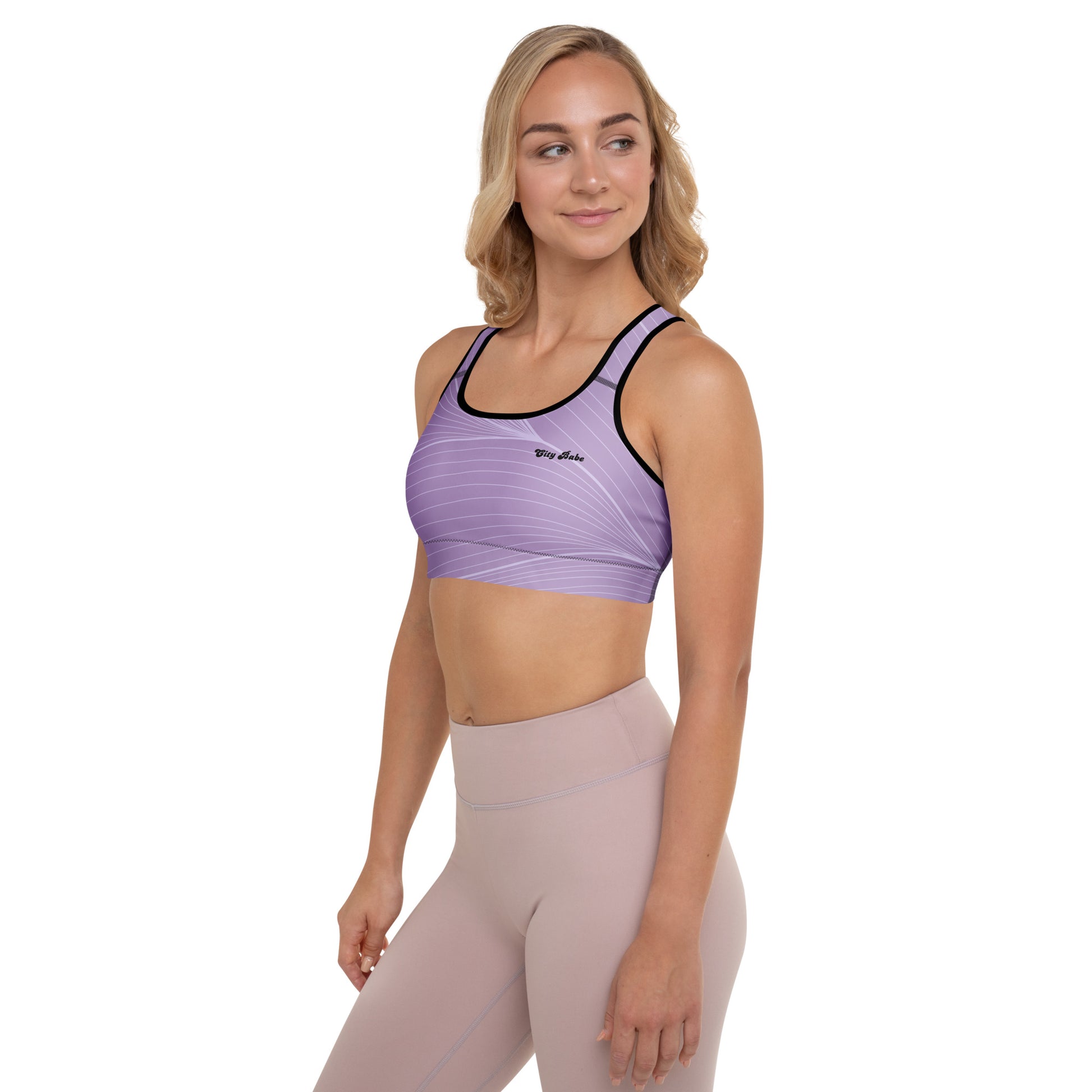 A model wearing the Roma Digital Atelier Performance Bra, showing the supportive fit, racer back design, and the graphic spiral lines in motion on the soft light lilac background.
