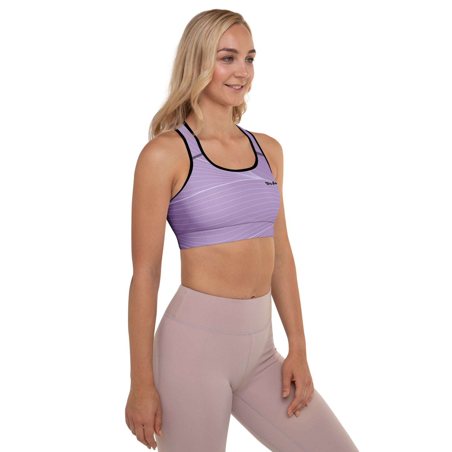 A model wearing the Roma Digital Atelier Performance Bra, showing the supportive fit, racer back design, and the graphic spiral lines in motion on the soft light lilac background.