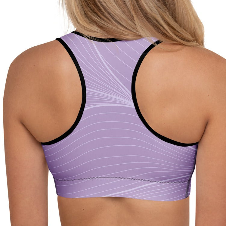 A model wearing the Roma Performance Bra, showing the supportive fit, racer back design, and the graphic spiral lines in motion on the soft light lilac background.