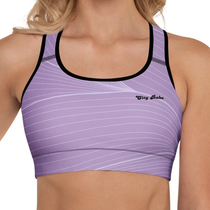 A model wearing the Roma Performance Bra, showing the supportive fit, racer back design, and the graphic spiral lines in motion on the soft light lilac background.