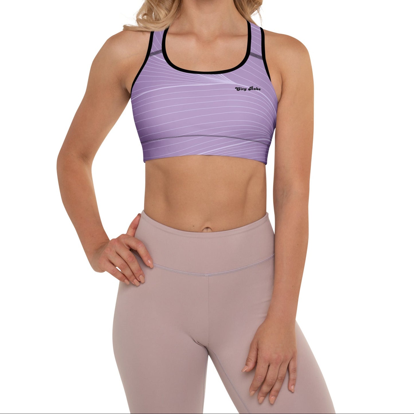 A model wearing the Roma Performance Bra, showing the supportive fit, racer back design, and the graphic spiral lines in motion on the soft light lilac background.
