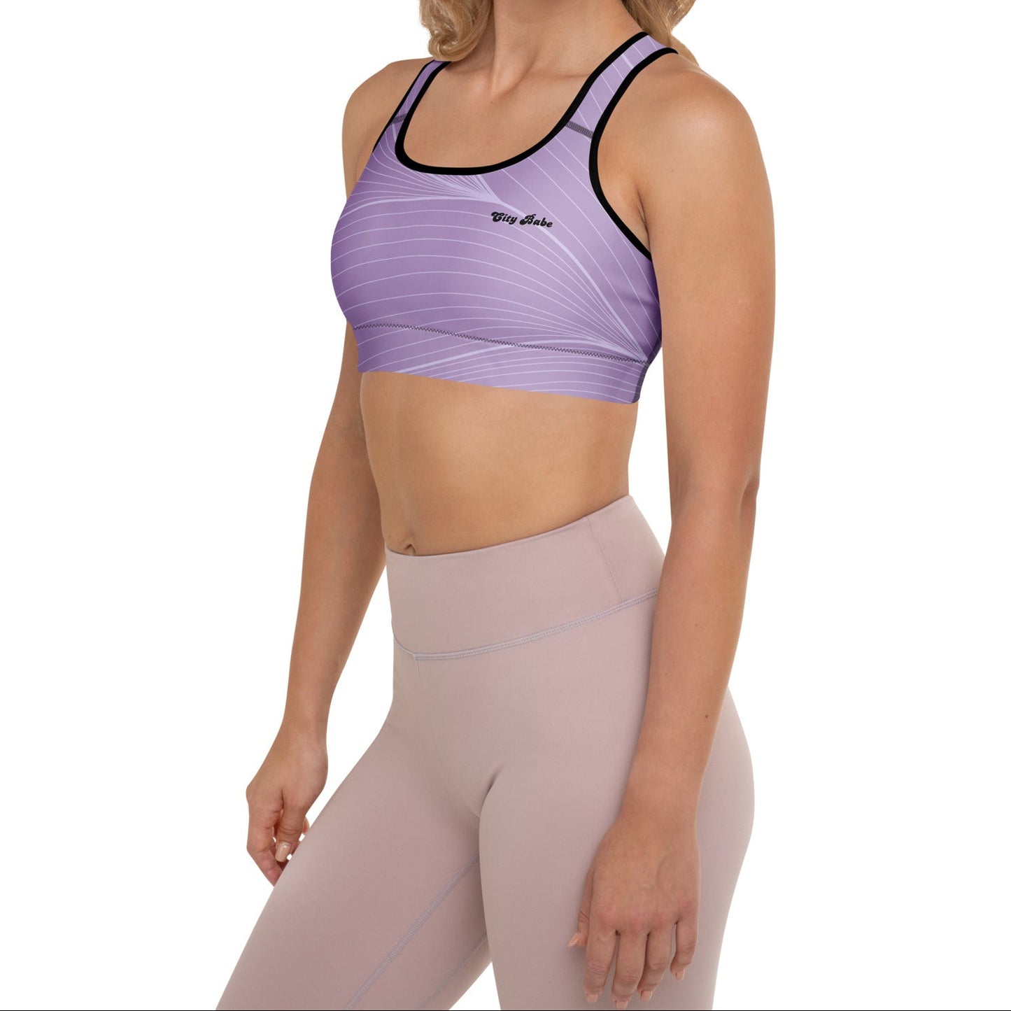A model wearing the Roma Performance Bra, showing the supportive fit, racer back design, and the graphic spiral lines in motion on the soft light lilac background.