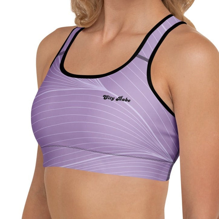 A model wearing the Roma Performance Bra, showing the supportive fit, racer back design, and the graphic spiral lines in motion on the soft light lilac background.