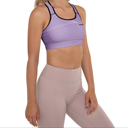 A model wearing the Roma Performance Bra, showing the supportive fit, racer back design, and the graphic spiral lines in motion on the soft light lilac background.