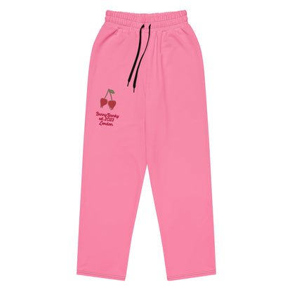 A close-up of The Seoul Pink Flow Wide Joggers, highlighting the playful Pop Cherry print, heritage logo, and the binary code pattern on the back left leg.