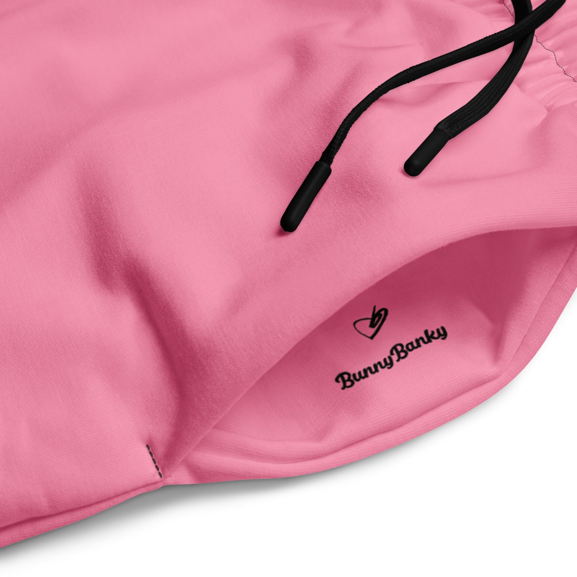 A close-up of The Seoul Pink Flow Wide Joggers, highlighting the playful Pop Cherry print, heritage logo, and the binary code pattern on the back left leg.