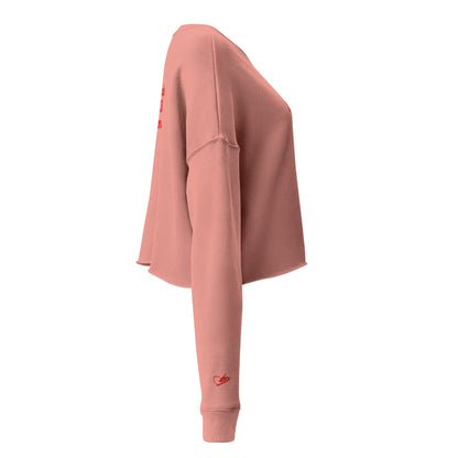 A close-up of The Sisterhood Crop Sweatshirt, highlighting the premium embroidery of the Iconic heart logo on the sleeve  and the soft, ring-spun cotton fabric texture.